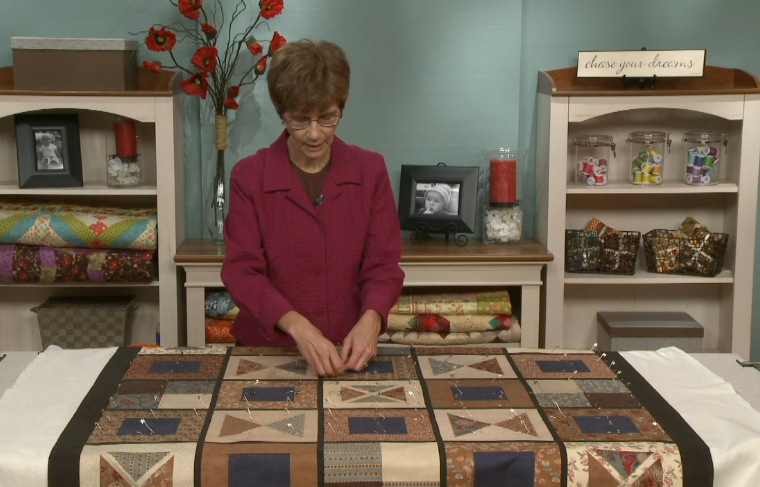 Woman pinning a large quilt