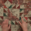 Person pointing to part of a quilt