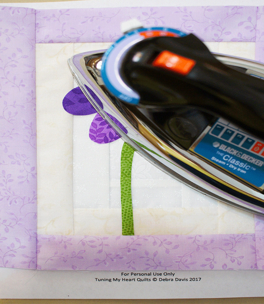 Ironing a purple quilted flower