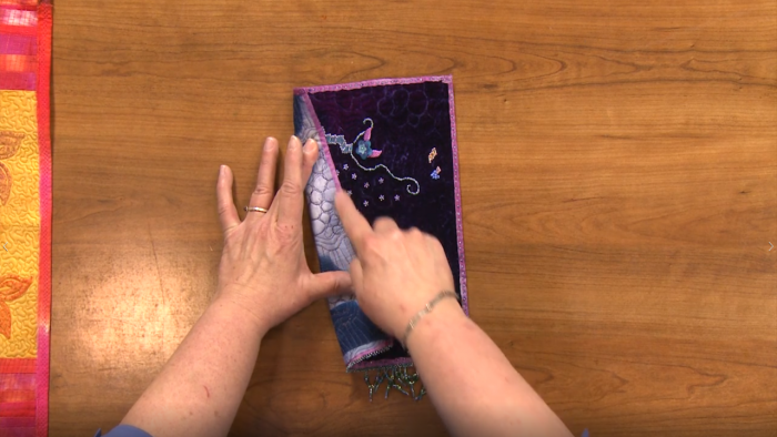 Folding over a piece of embroidered fabric