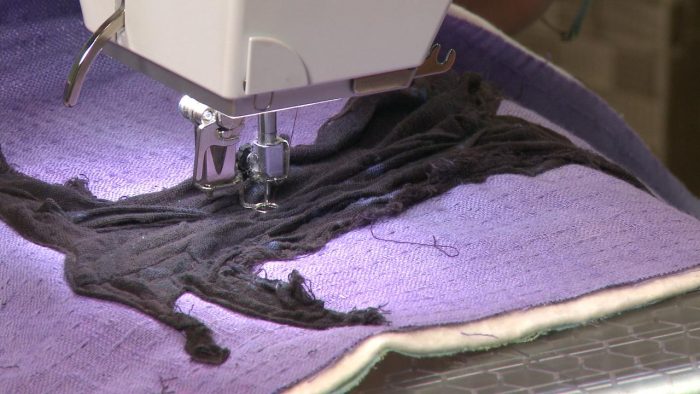Sewing black fabric in the shape of a tree