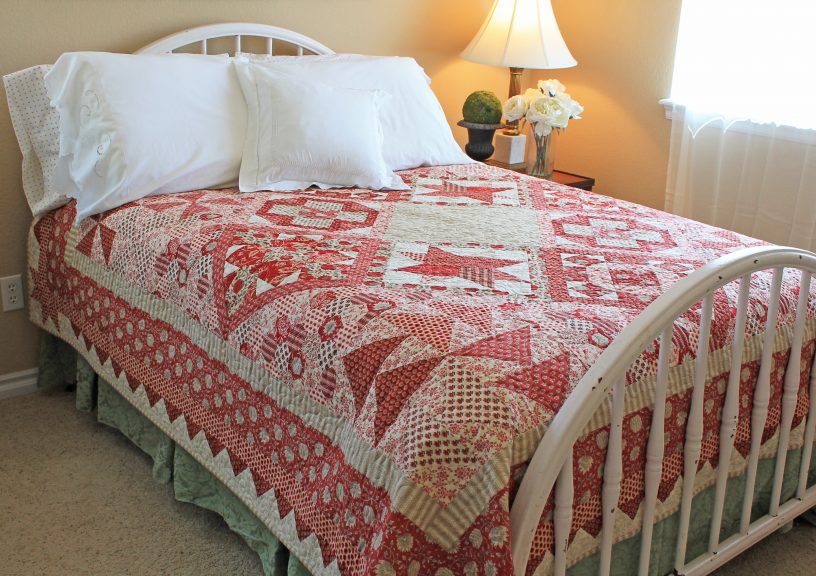 Red quilt on a twin bed