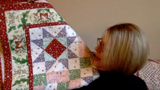 Woman holding up a quilt
