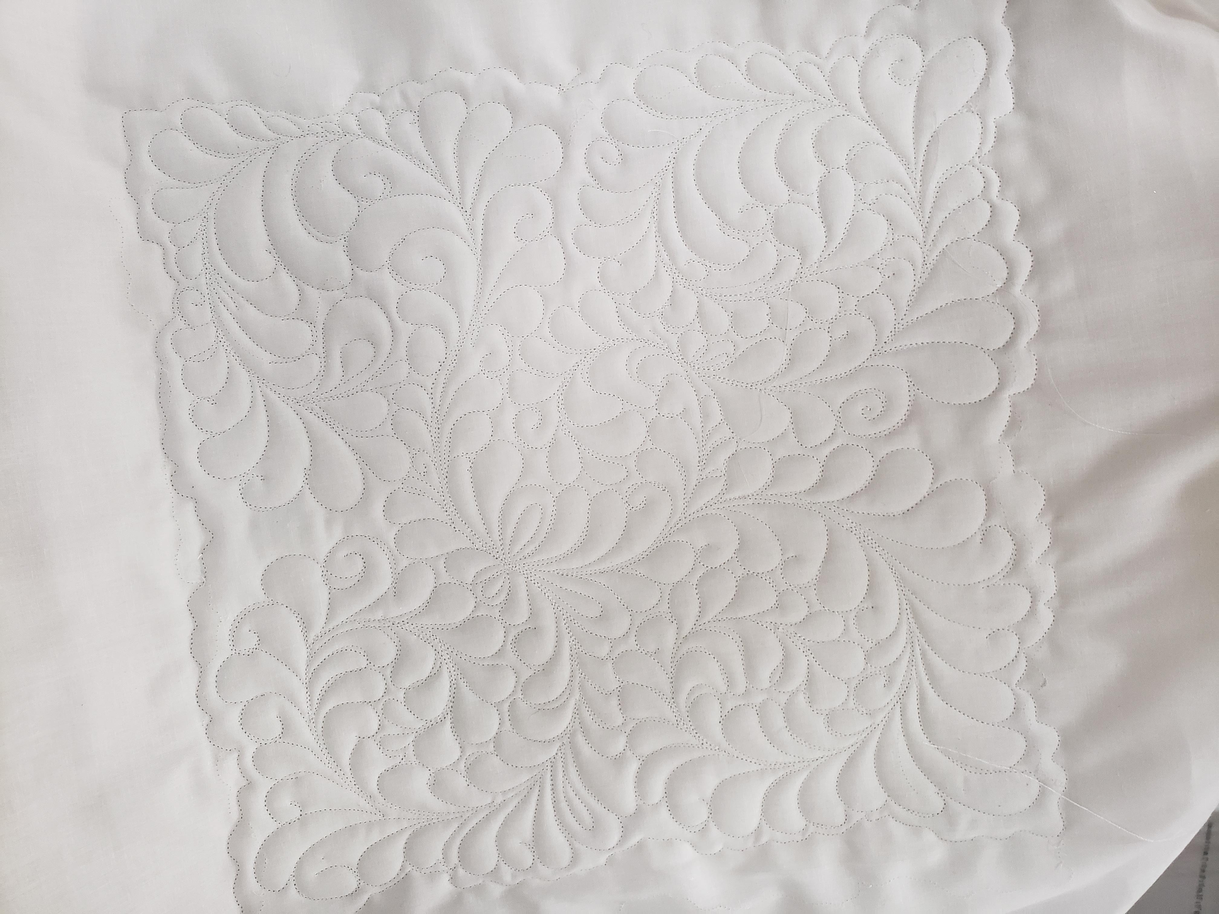 white quilt with design stitching