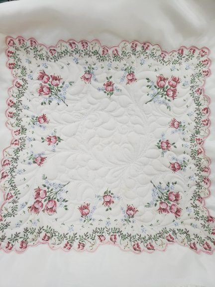 white quilt with pink flower border