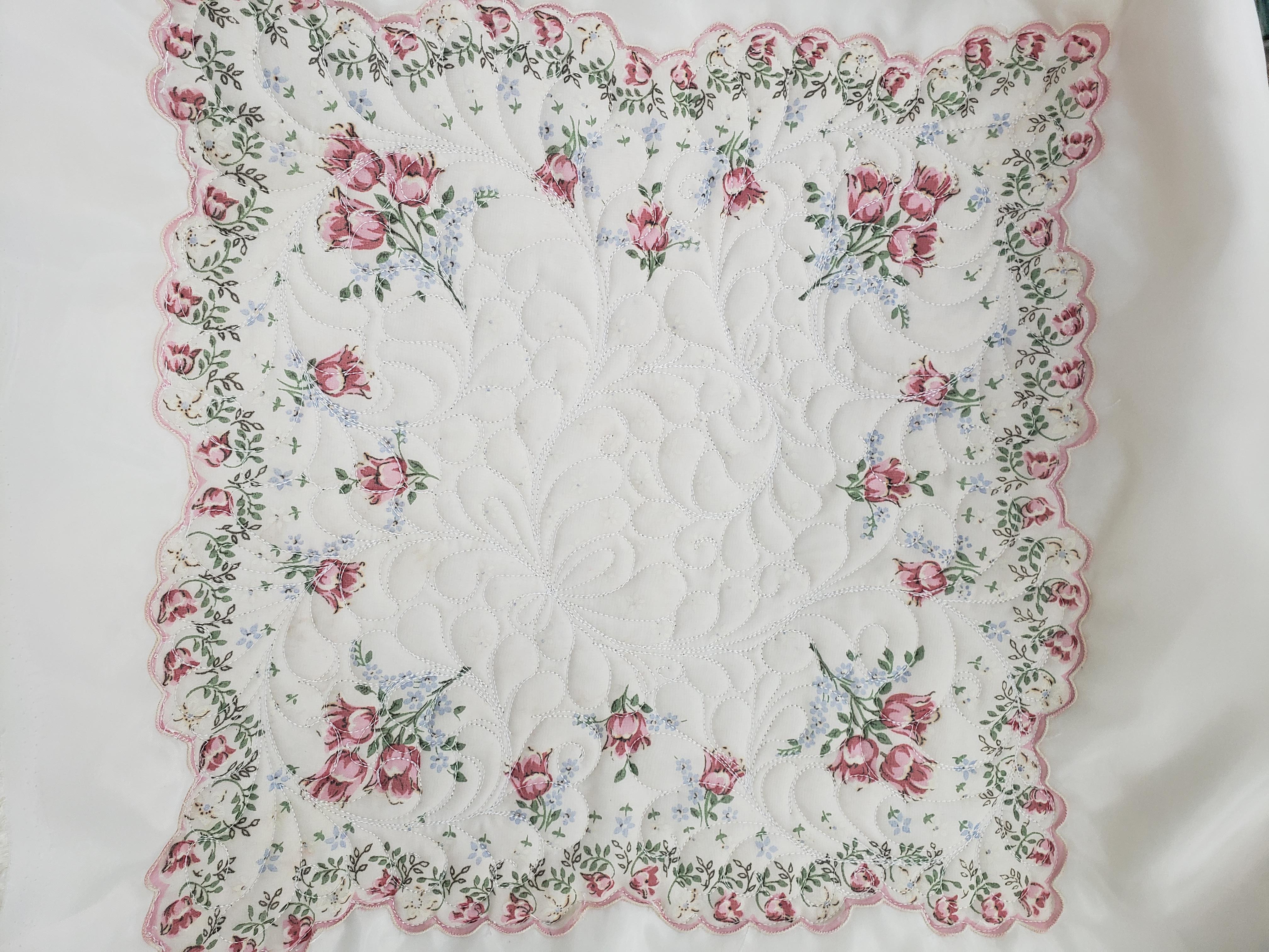 white quilt with pink flower border