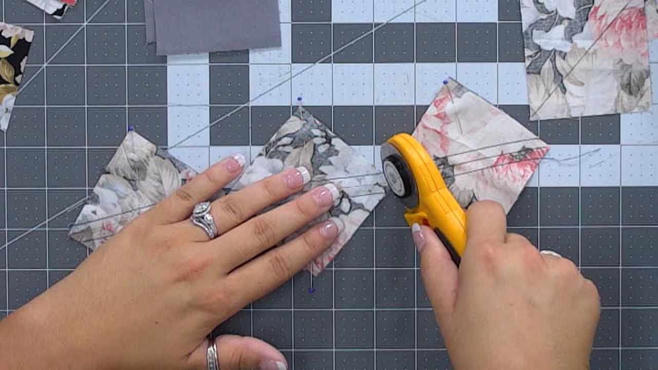 image of two hands using a round cutter to cut three pieces of fabric