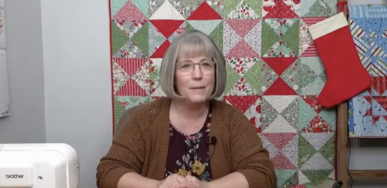 Woman in front of a Christmas quilt