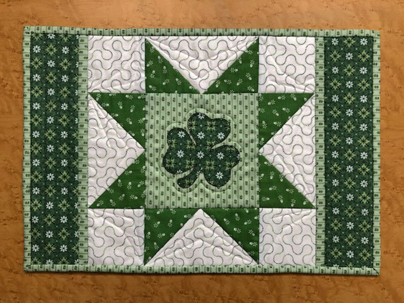 green and white quilt with a clover