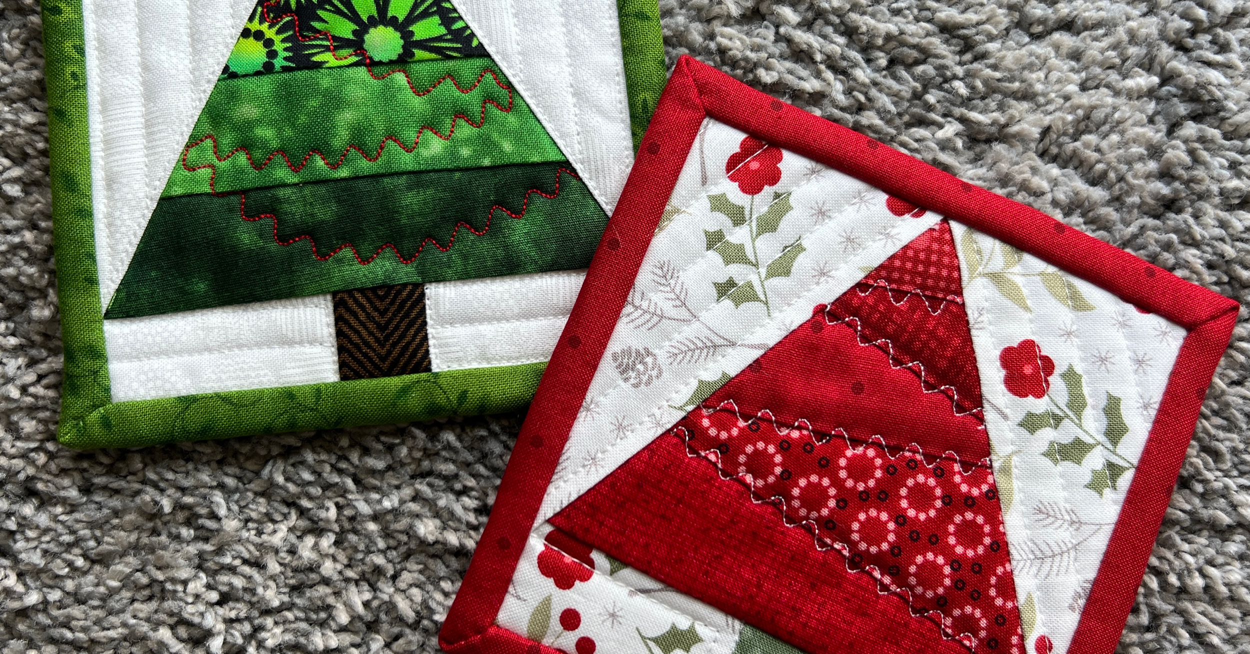 two quilted Christmas tree coasters in red and green