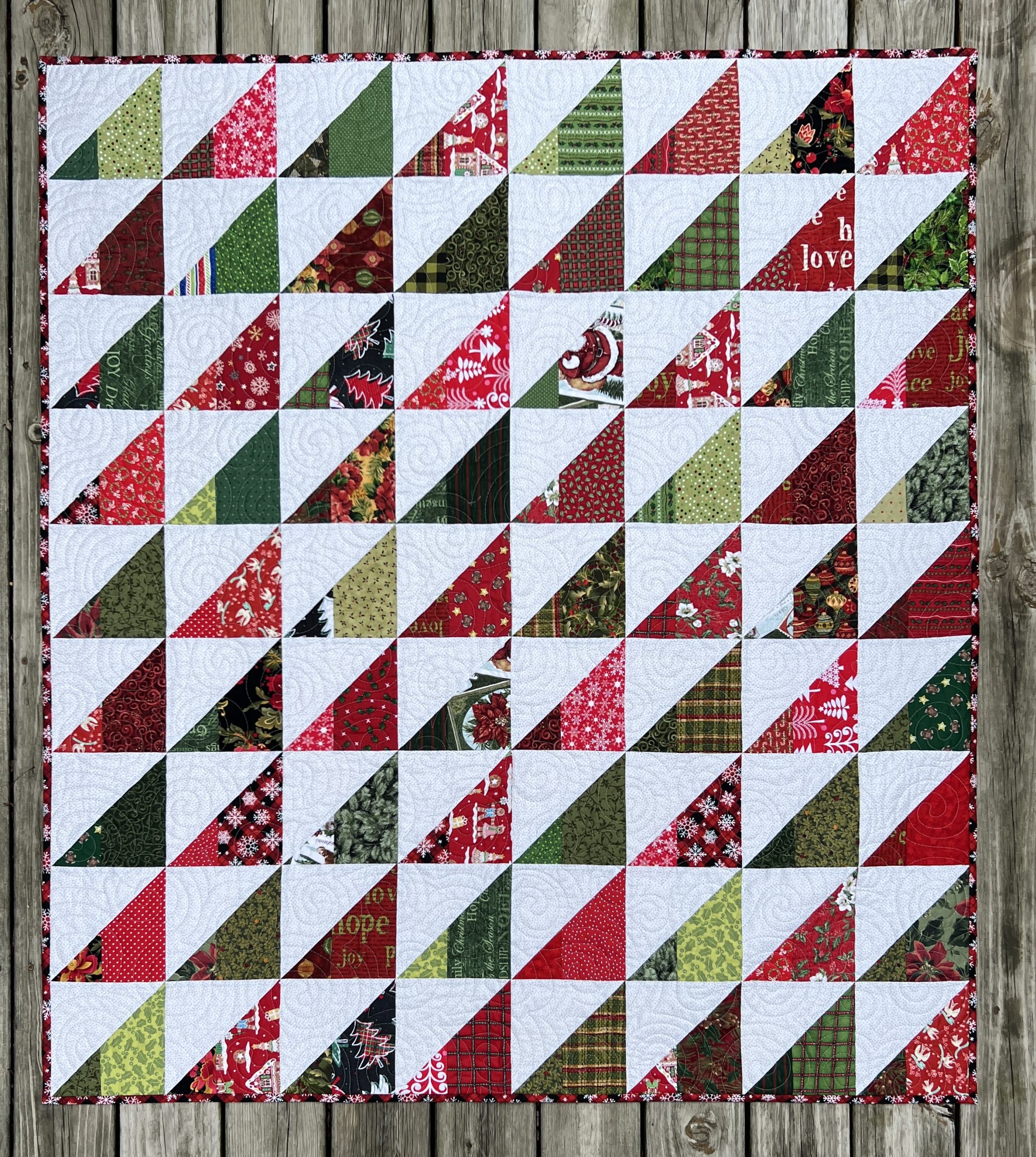 a large Christmas quilt of all triangles in white, green, and red