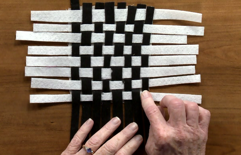 Weaving black and white strips of fabric