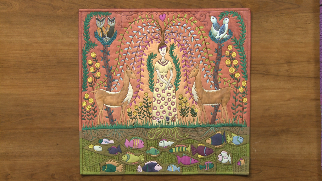 Quilted image of a woman with fish and birds