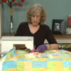 Woman quilting wearing purple gloves