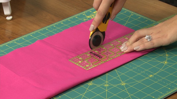 Cutting pink fabric with a rotary cutter