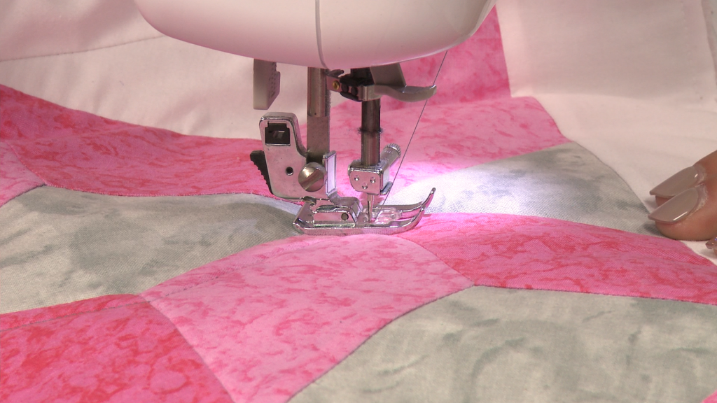 Sewing pink and white quilt