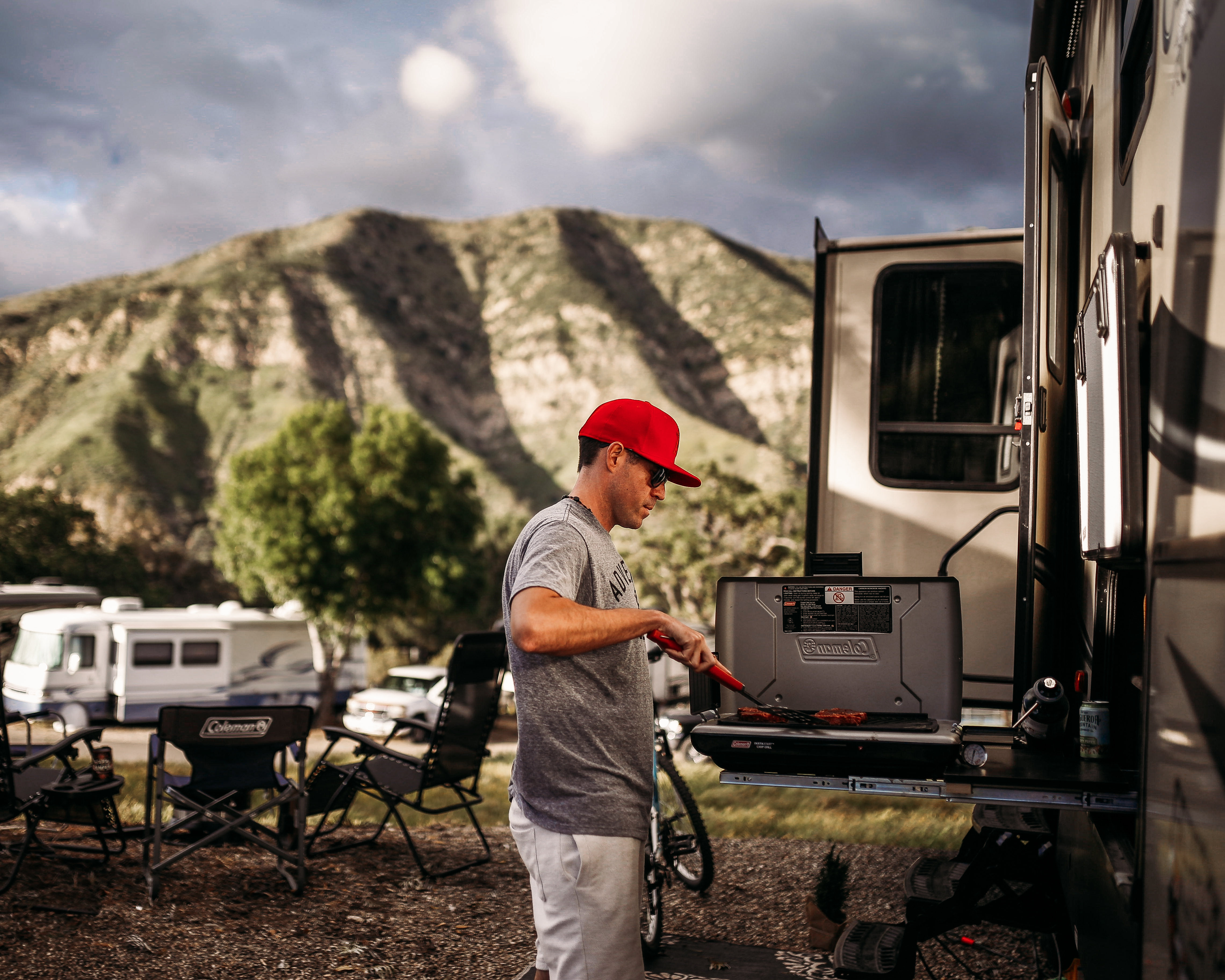 Person cooking on an outdoor grill on an RV