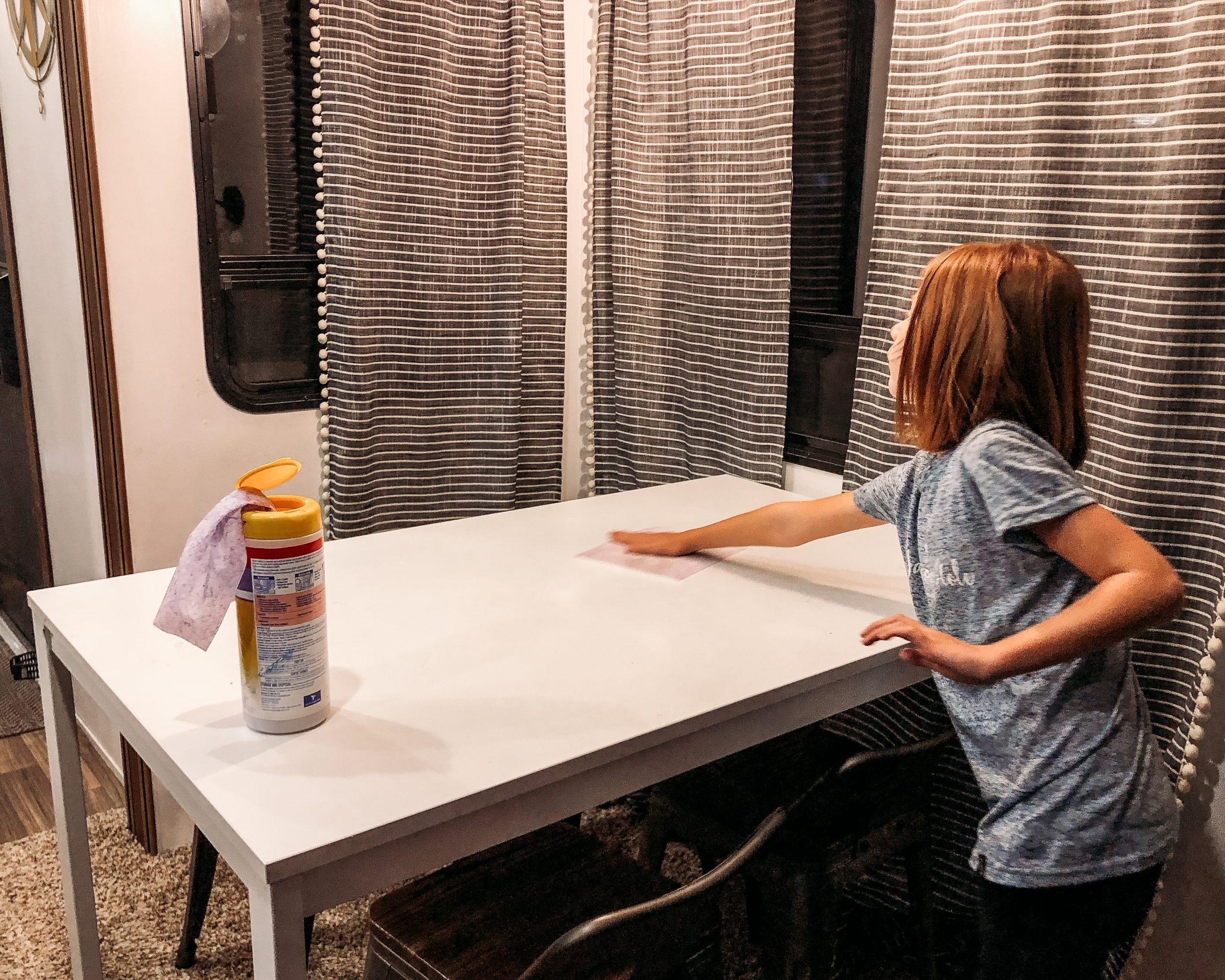 Kid cleaning a table in an RV