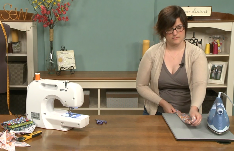 Woman ironing at a sewing table