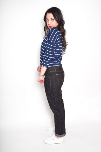 Girl in a striped top modeling dark denim jeans