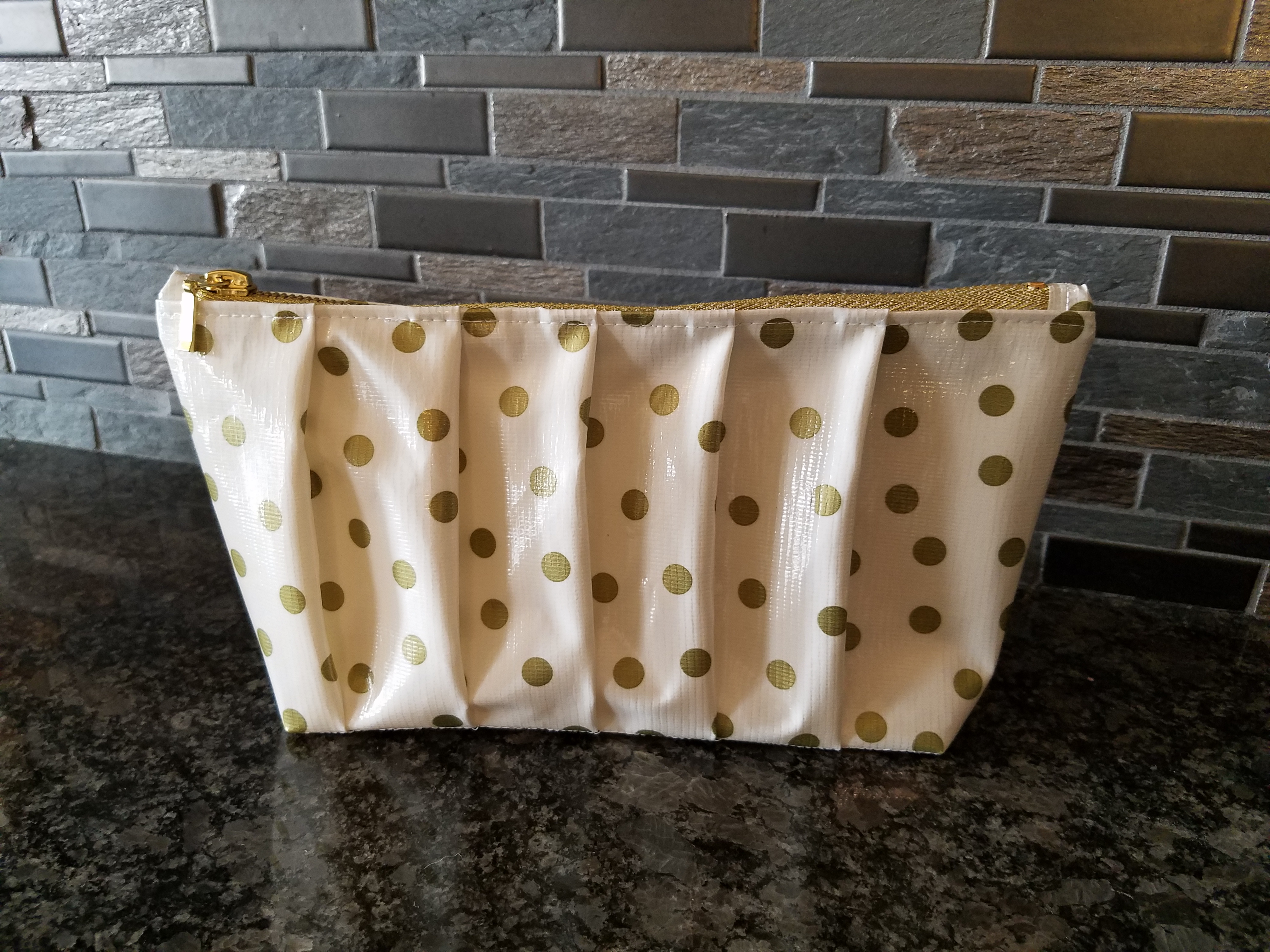 Pleated polka dot oilcloth clutch