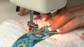 Sewing an embellishment on a towel