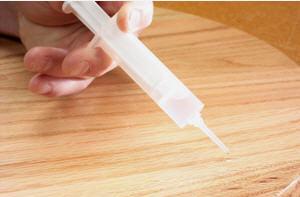 Photo 3. I apply distilled water to the holes and to the chips that were pushed up by the screws to swell the fibers of the wood. The syringe allows for water to precisely drip on the mistakes and the surrounding chips.