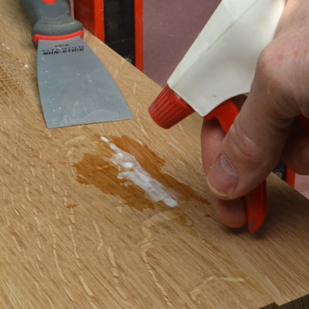 spraying leftover glue on a board
