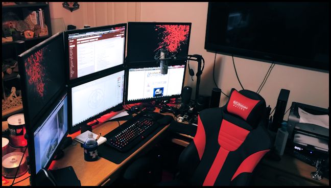 desk with multiple computer screens