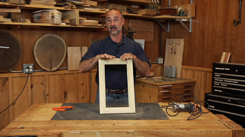 Man holding a wooden frame