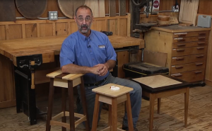 Man with wooden stools and small tables