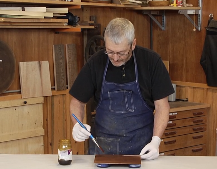 Man staining wood