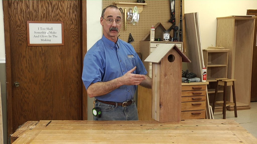 Man with a wooden birdhouse
