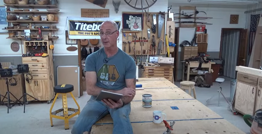 Man holding a tablet in a wood workshop