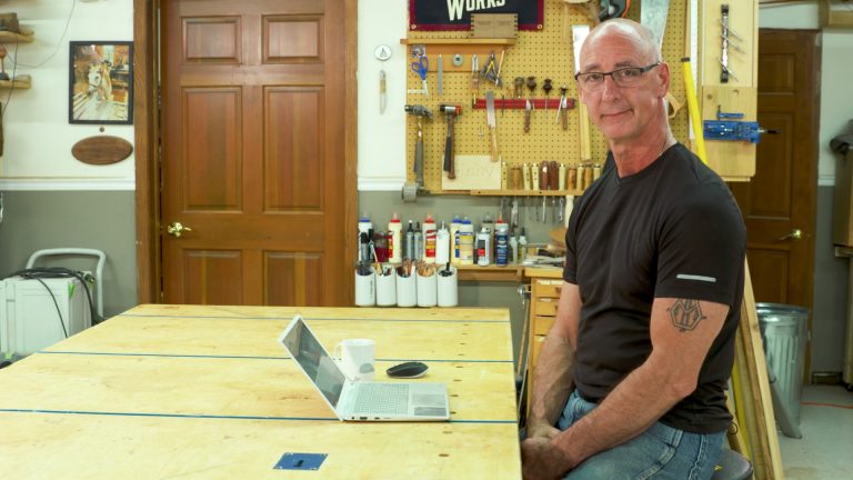 Man sitting at a laptop in a workshop