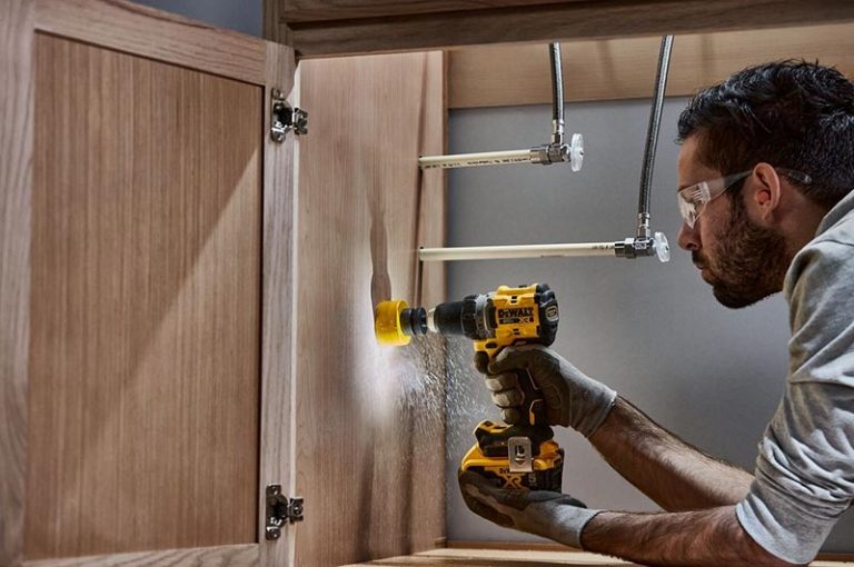 Man drilling into a cabinet