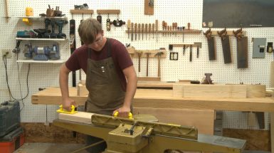 Man using a jointer in a wood work shop
