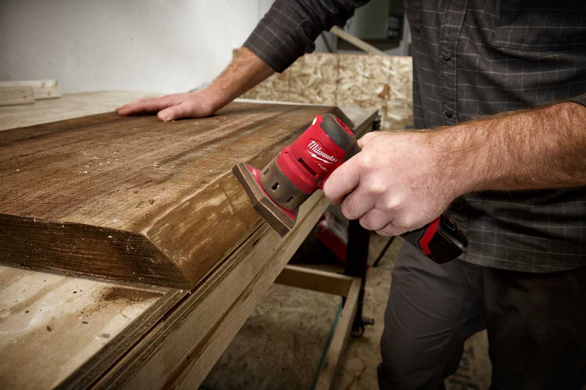 person using a cordless sander