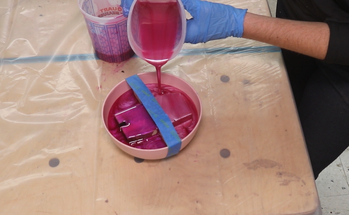 pouring pink epoxy into a bowl