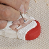 Painting a wooden Santa carving