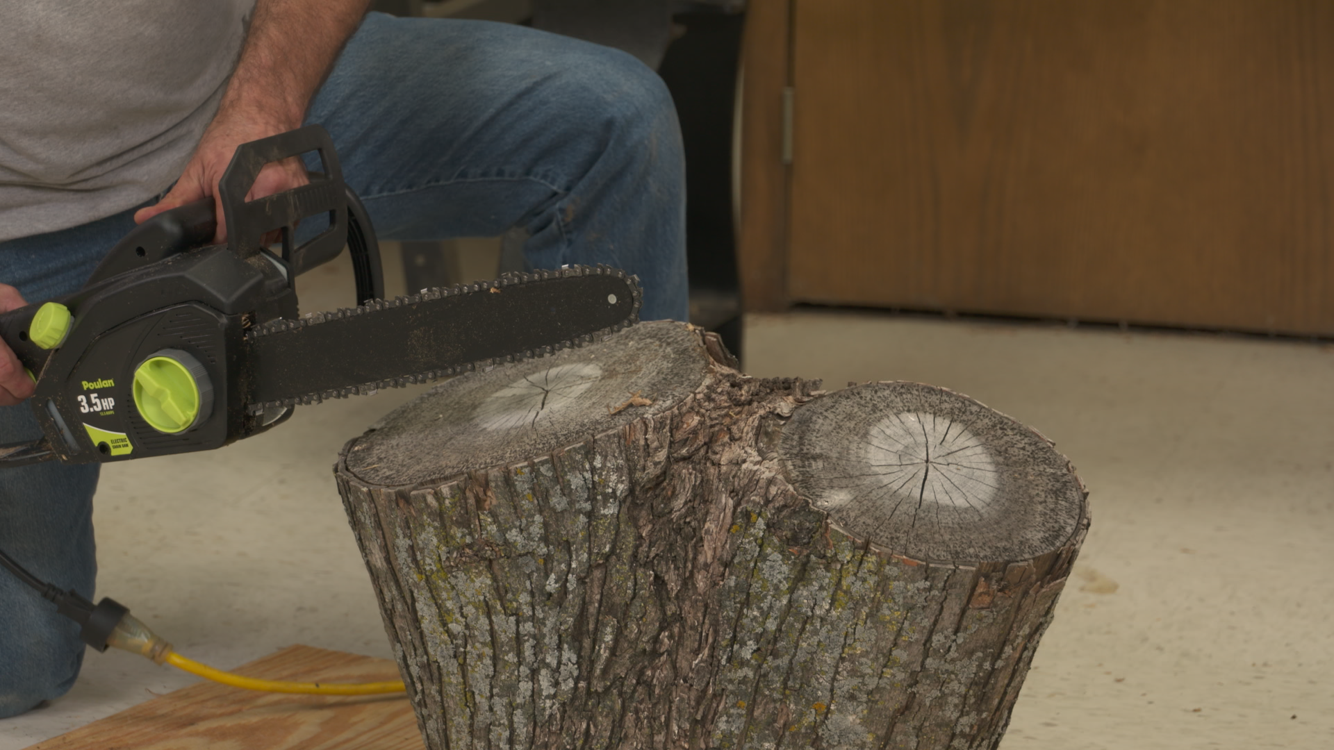Electric chainsaw into a log